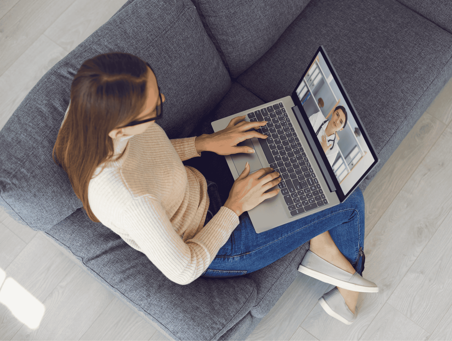 Woman using laptop on a couch for telehealth consultation